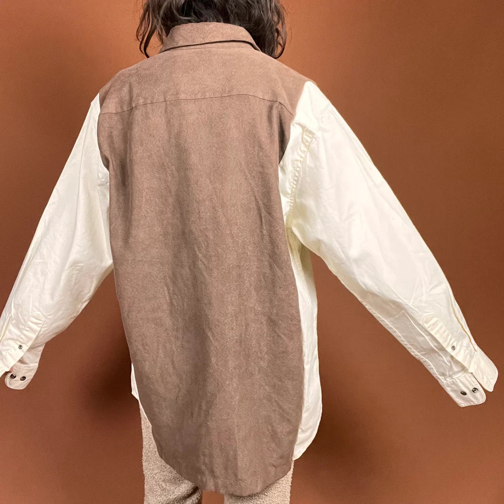 a person standing in front of a brown wall.