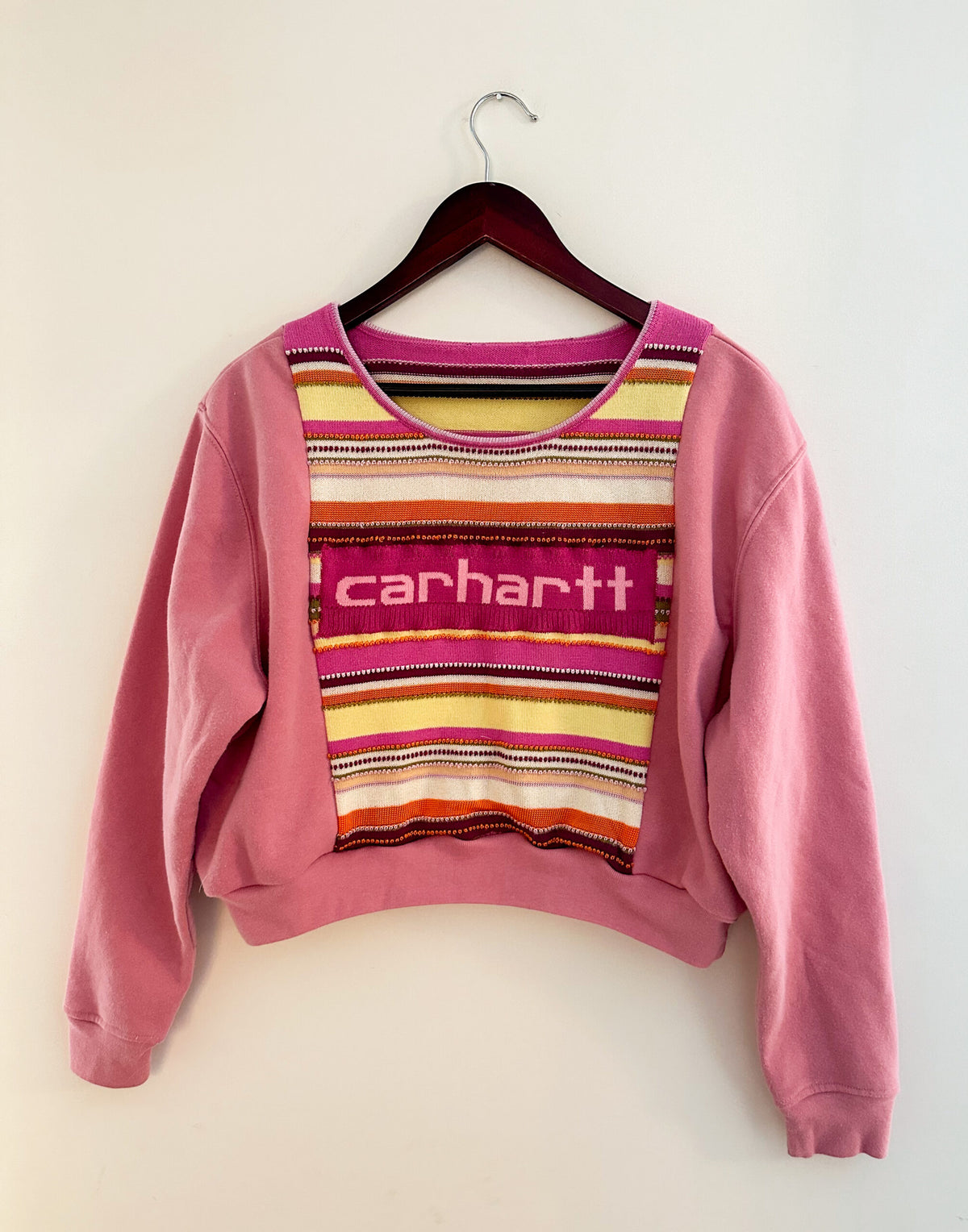 A pink sweater with the word carhartt on it.