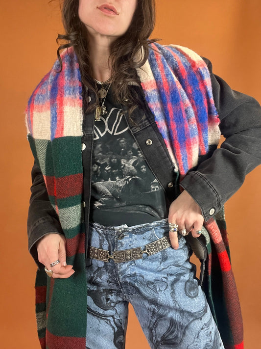 A woman wearing jeans and a plaid scarf.