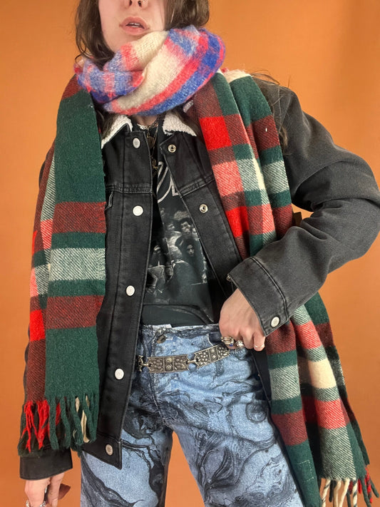 A woman wearing a plaid scarf and jeans.