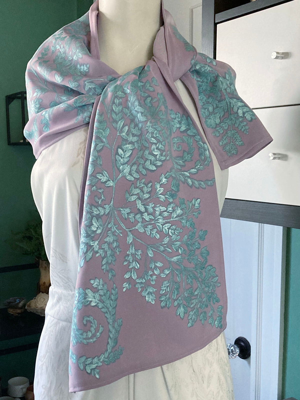 Lavender scarf with a shimmery turquoise fern design painted on, tied around the neck