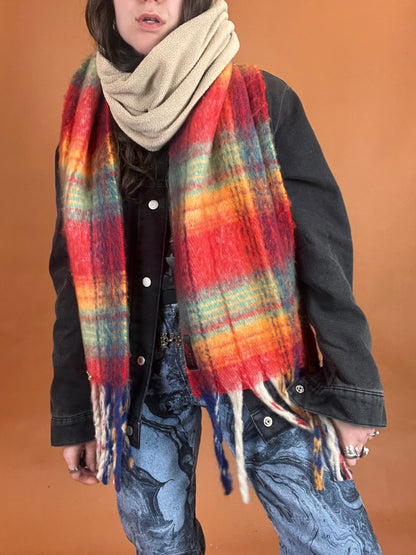 A woman wearing a colorful scarf and jeans.