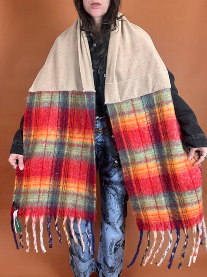 A woman wearing a plaid scarf with fringes.