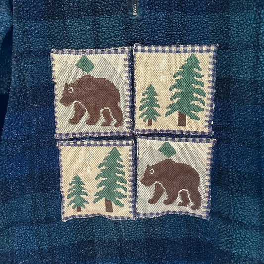 A blue flannel shirt with bears and trees on it.