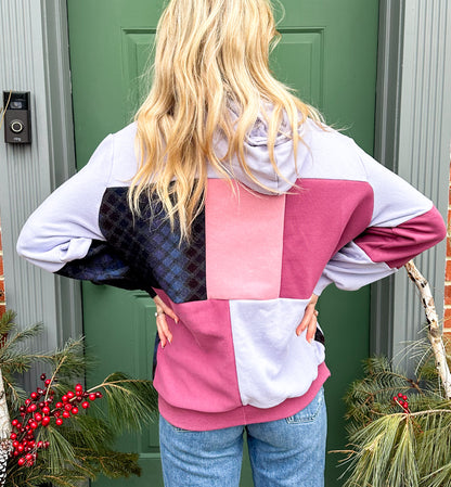 The back of a woman wearing a pink and purple hoodie.