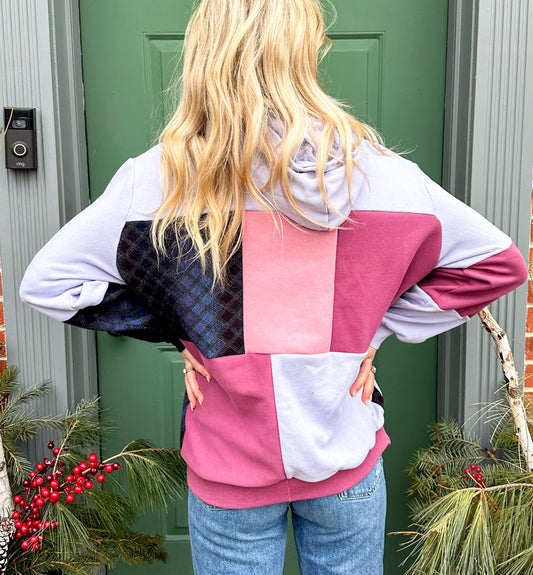 The back of a woman wearing a pink and purple hoodie.