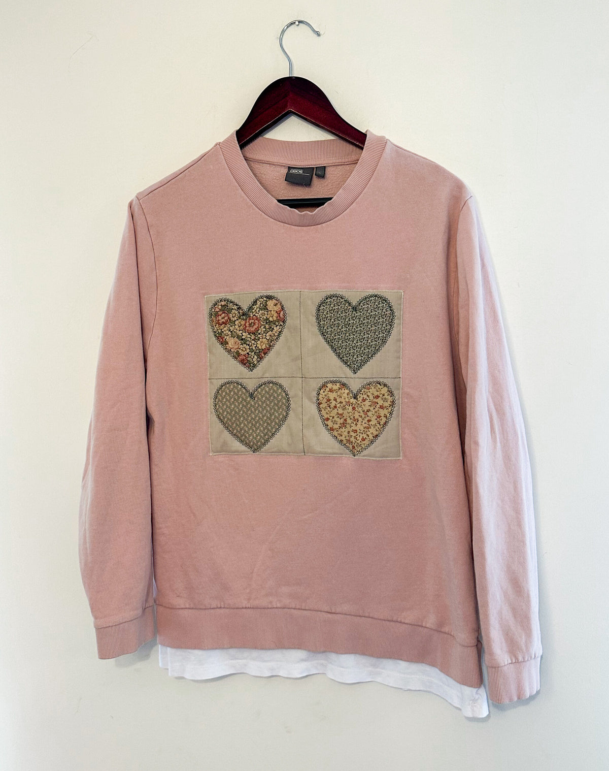 A pink sweatshirt with hearts on it.