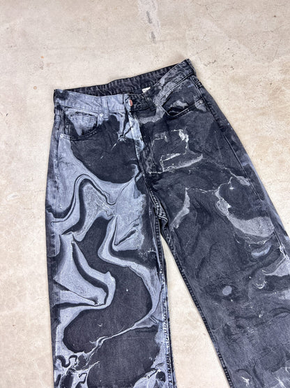 A pair of black and white marbled jeans.