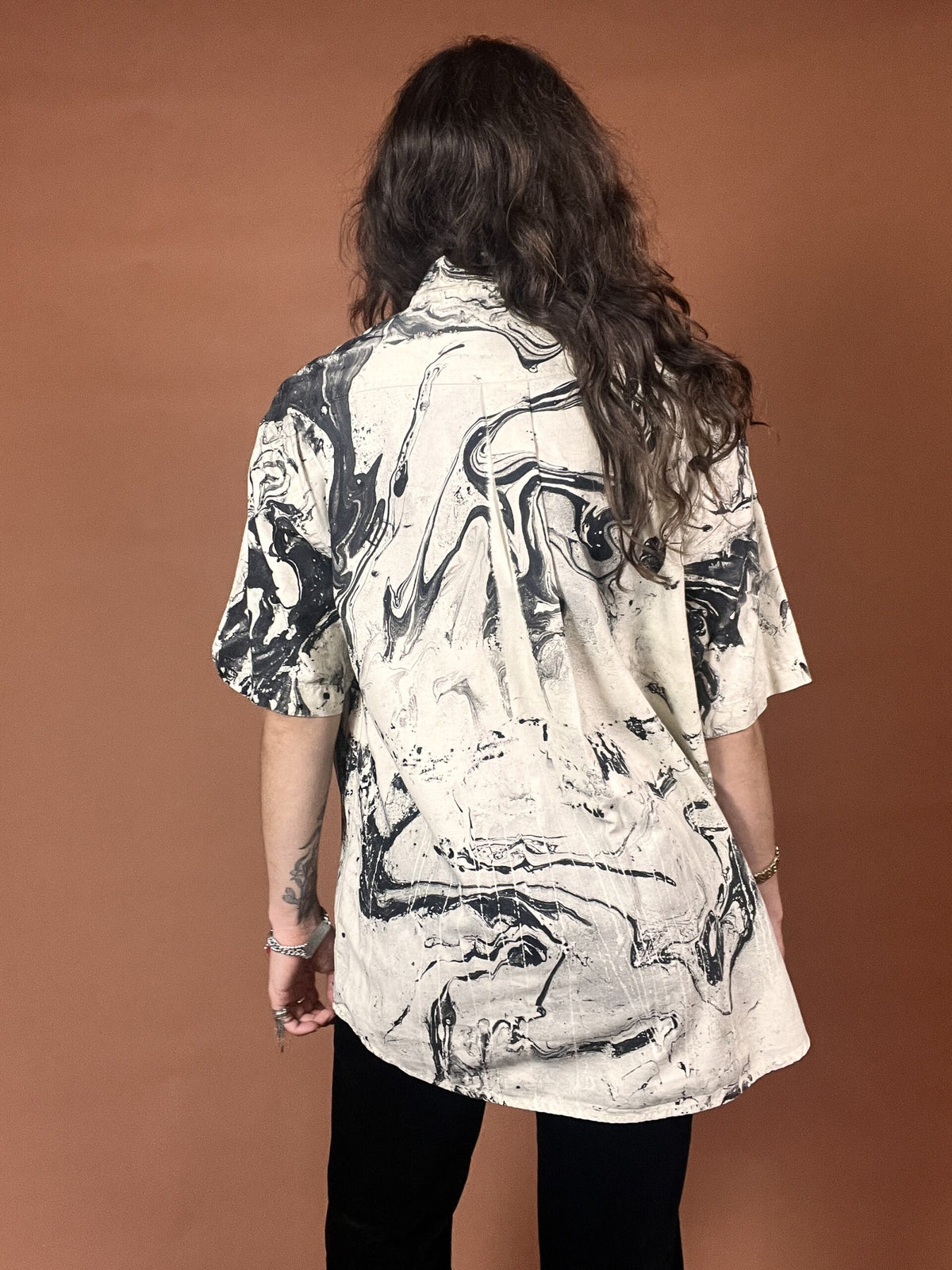 The back of a woman wearing a black and white shirt.
