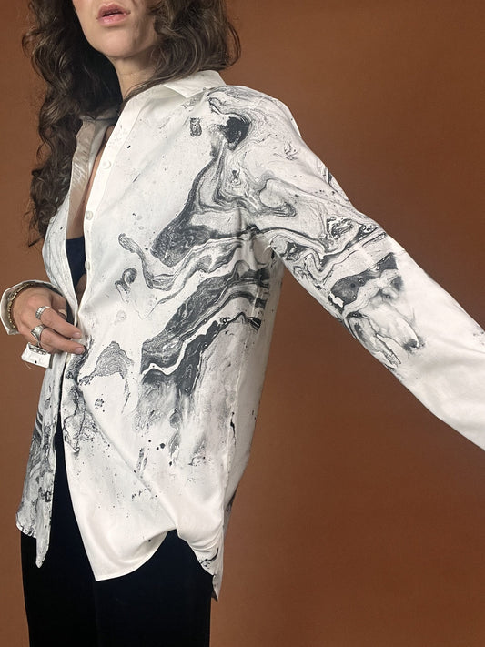 A woman wearing a white shirt and black pants.