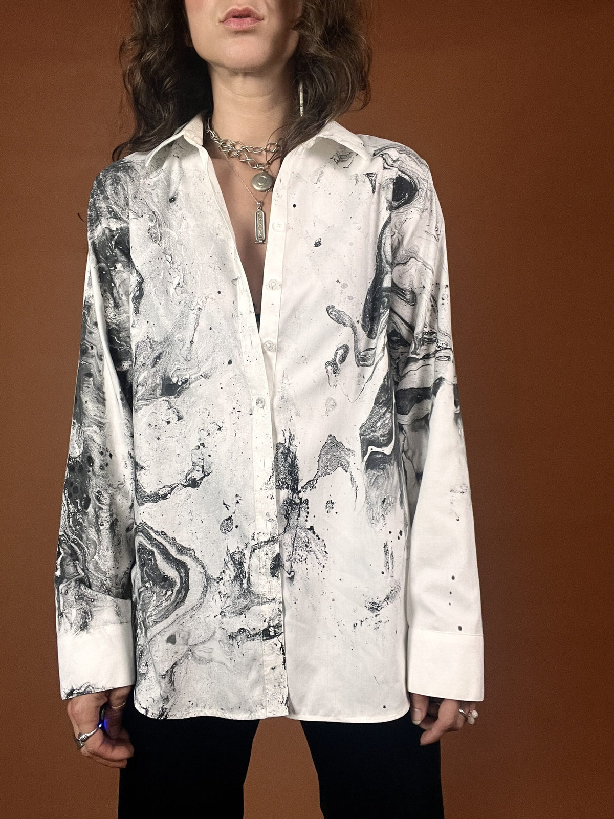 A woman wearing a white shirt with black and white paint on it.