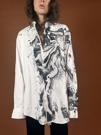 A woman wearing a shirt with a black and white painting on it.