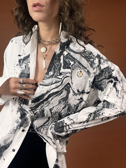 A woman wearing a white and black marble print shirt.