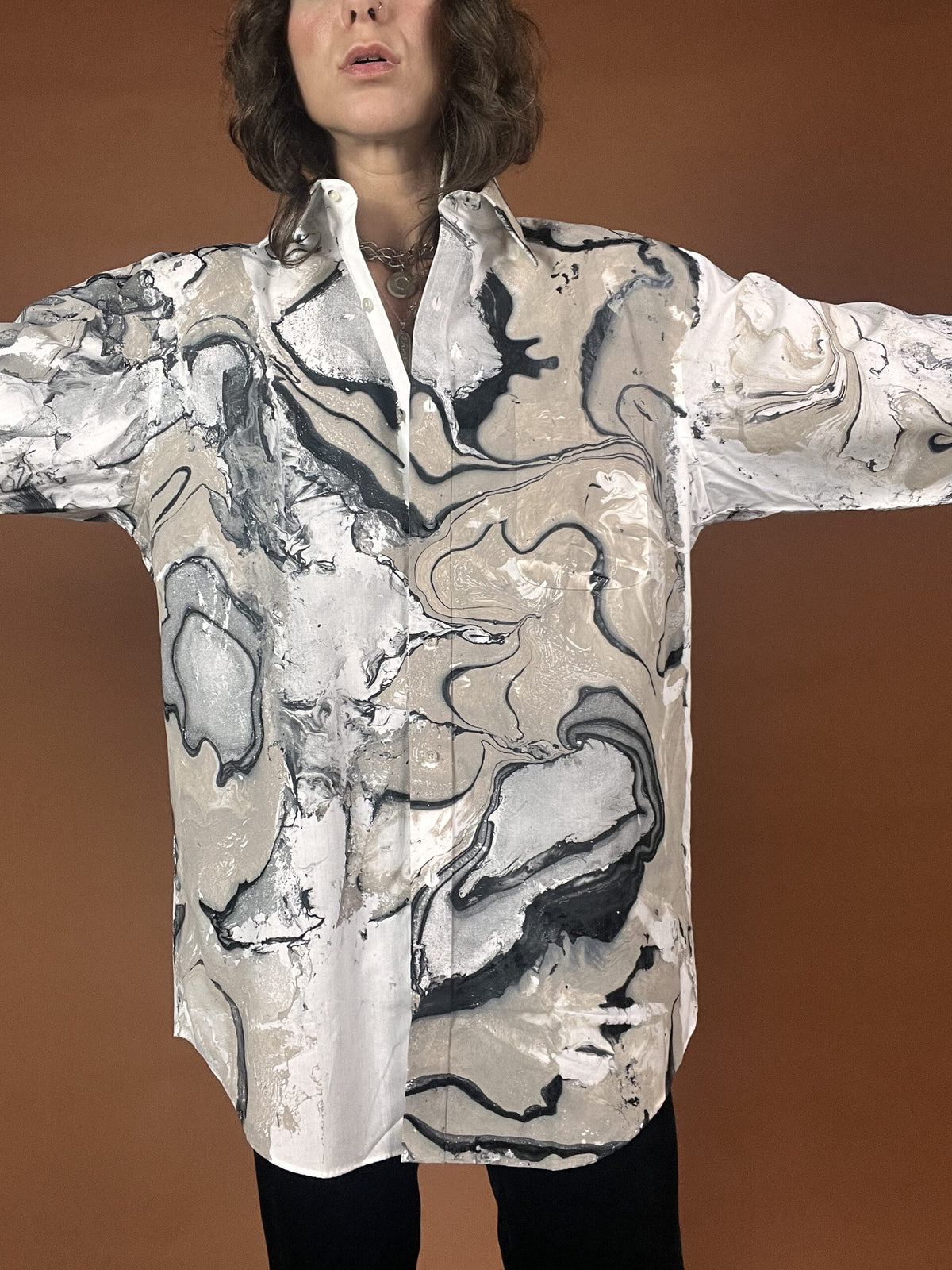 A woman wearing a shirt with a marble print.