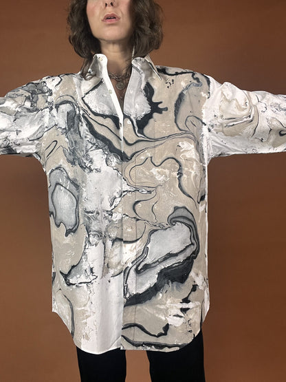 A woman wearing a shirt with a marble print.