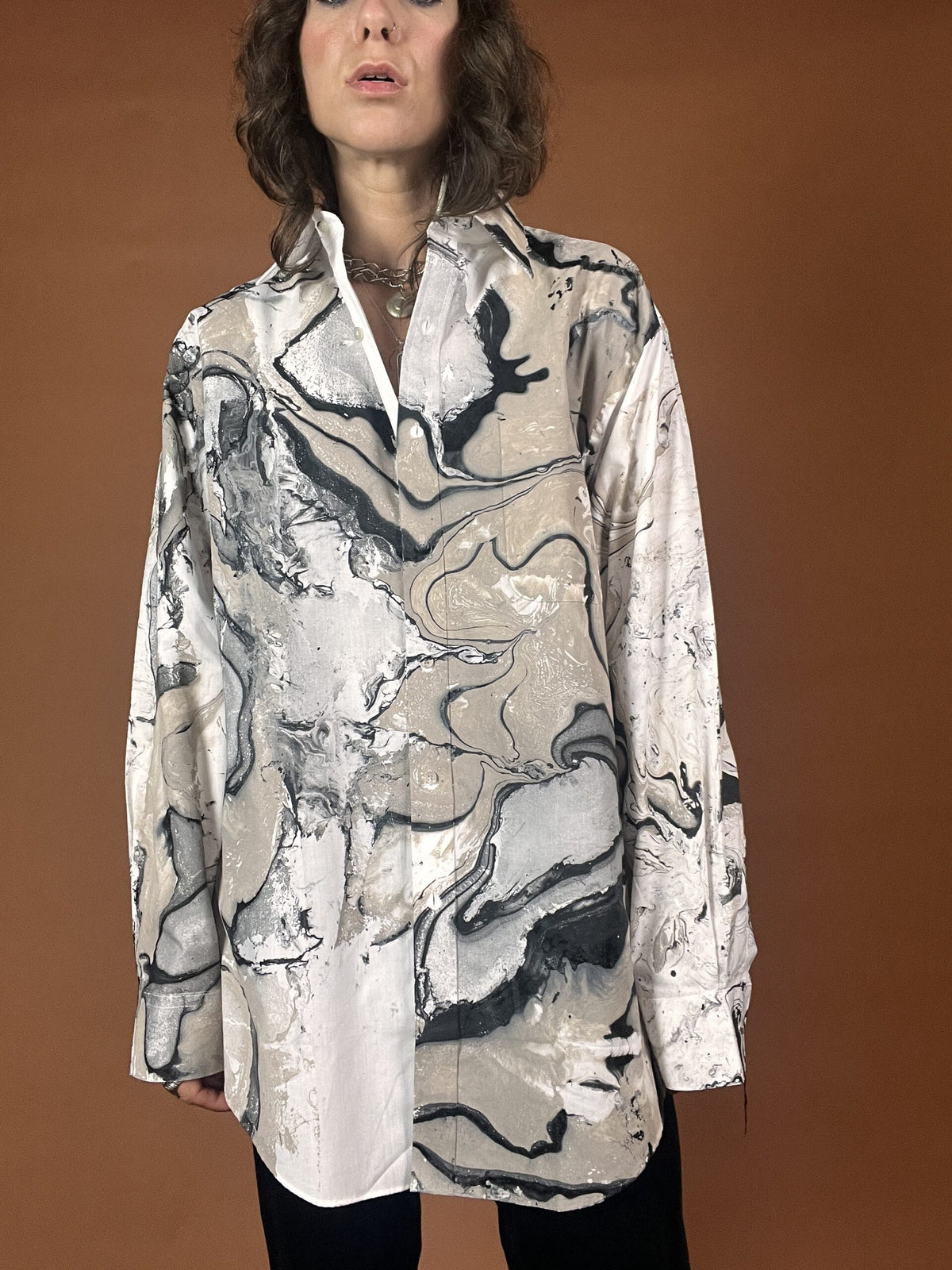 A woman wearing a shirt with a marble print.