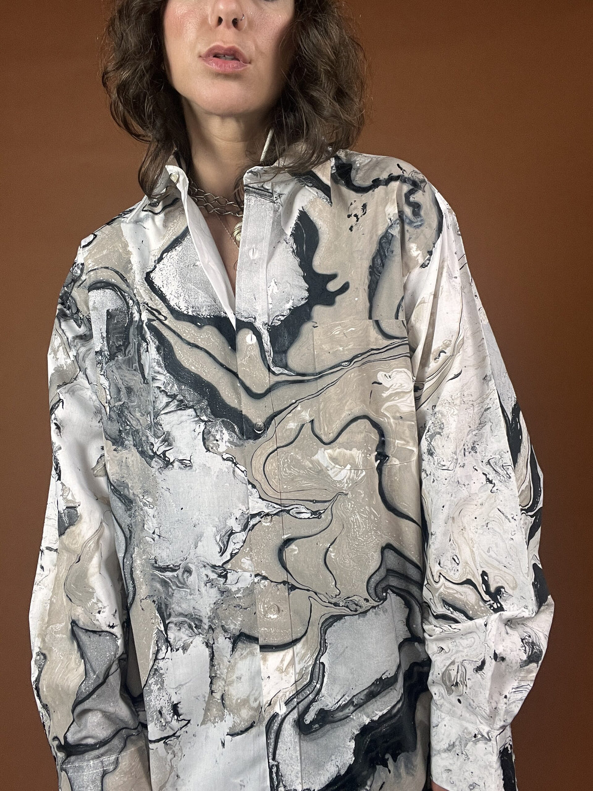 A woman wearing a shirt with a marble print.