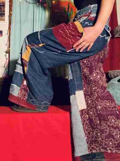 a woman sitting on top of a pile of clothes.