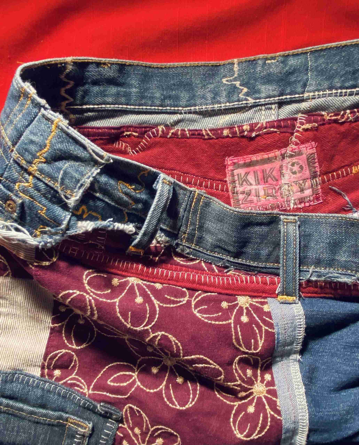 a pile of different colored jeans sitting on top of each other.