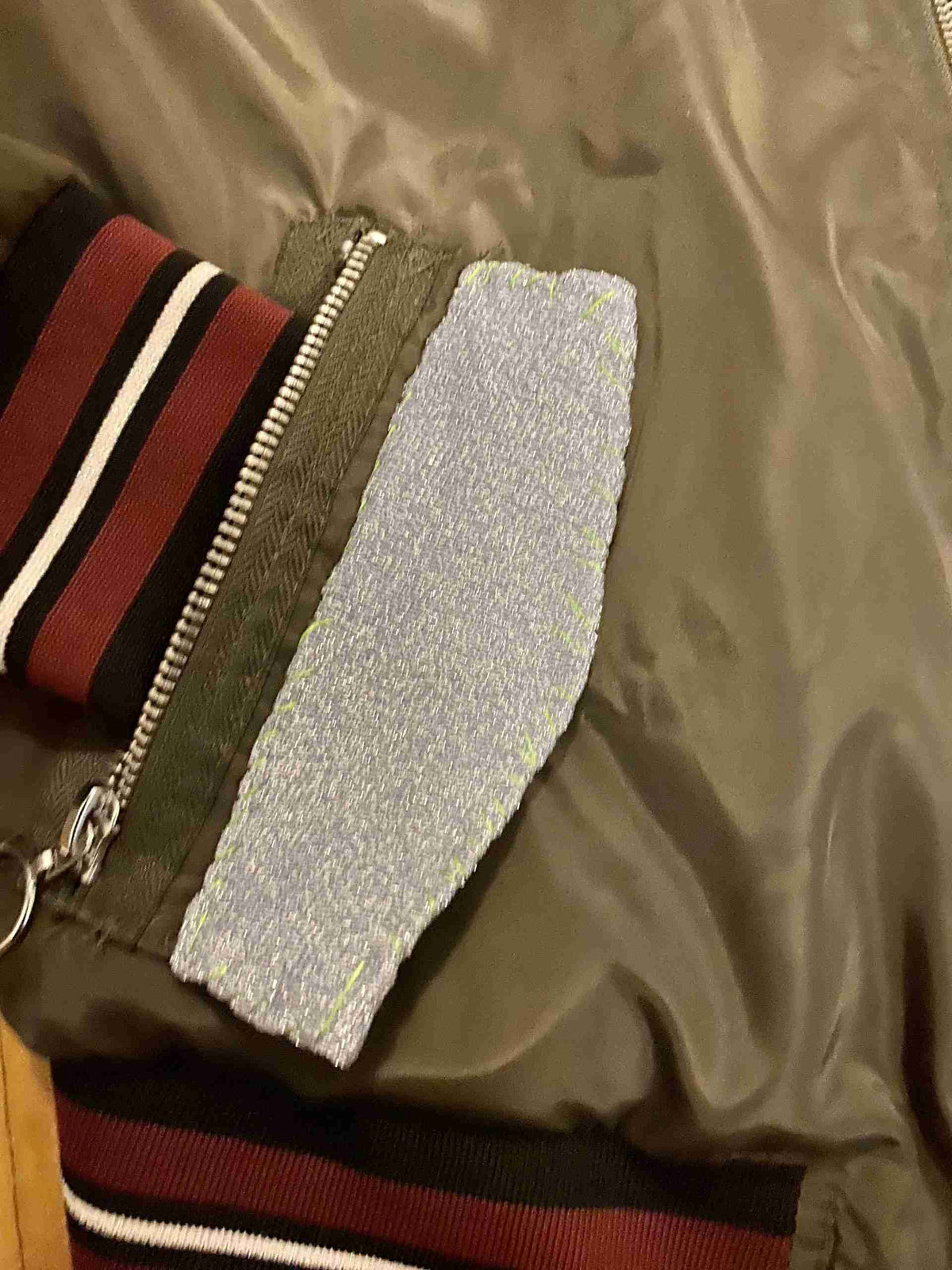 a jacket with a zipper and a striped tie.