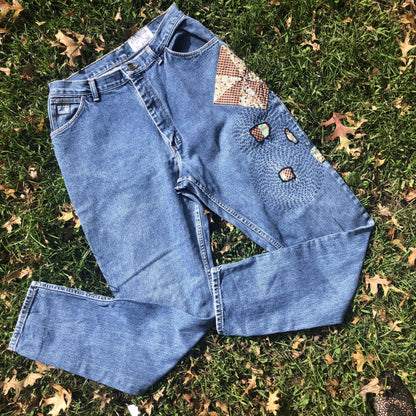 A pair of blue jeans laying in the grass.