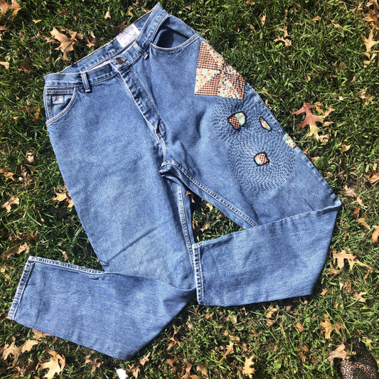 A pair of blue jeans laying in the grass.