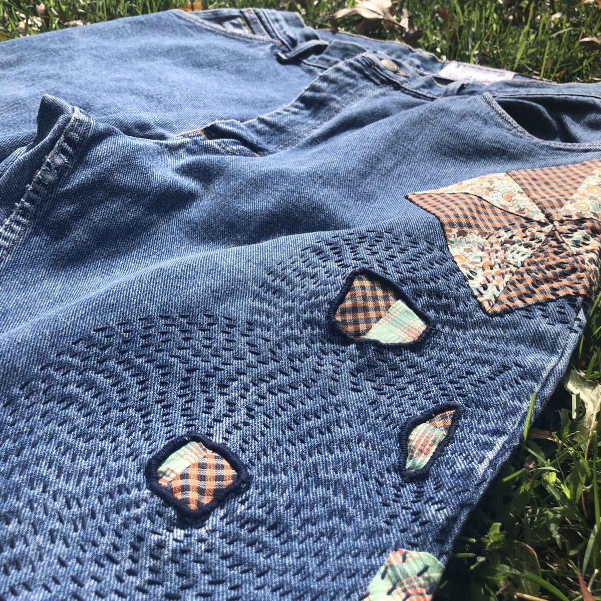 A pair of denim jeans with patches on them.