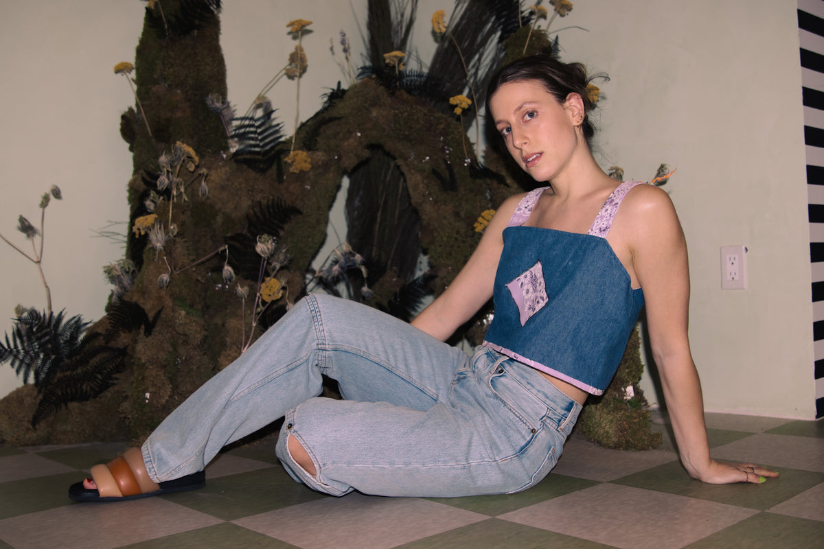 A woman sitting on the floor in jeans and an Upcycled Denim Crop Top, Vintage Purple Bandana Straps, S/M.