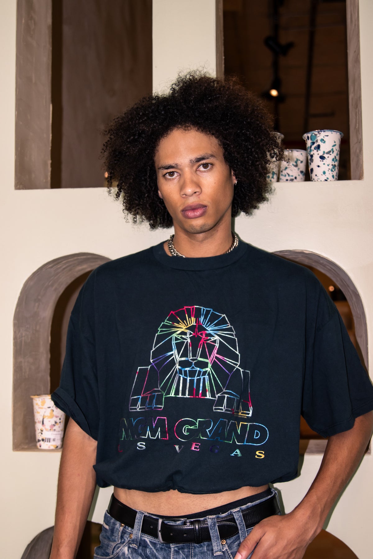 A young man wearing a black t - shirt and jeans.