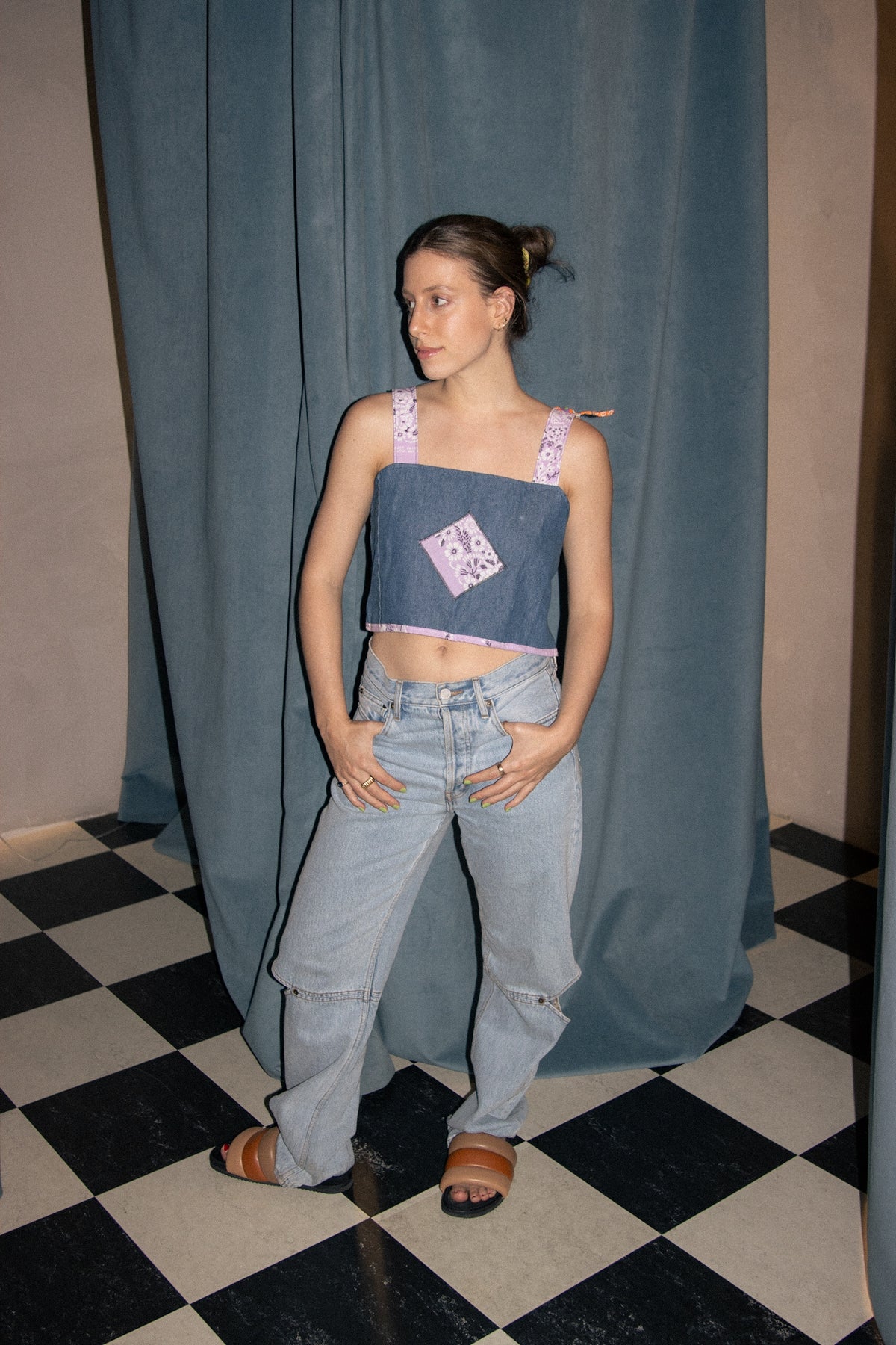 A woman standing in front of a checkered floor.