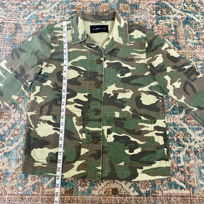A camouflage jacket on a rug.