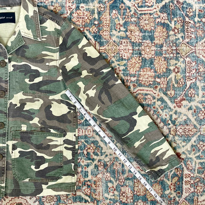 A camouflage jacket on a rug.