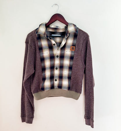 A brown and tan plaid sweater hanging on a wall.