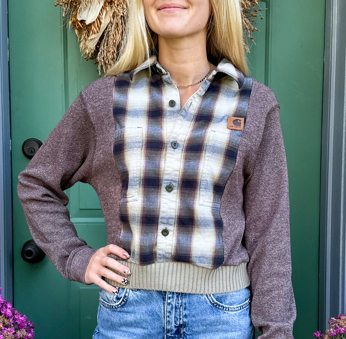 A blonde woman wearing a plaid shirt and jeans.
