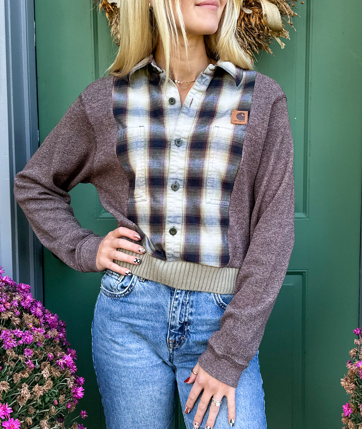 A blonde woman wearing jeans and a plaid shirt.