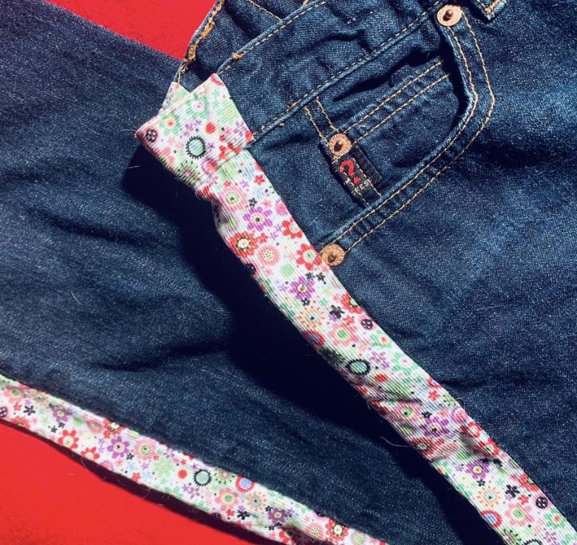 a pair of jeans laying on top of each other.
