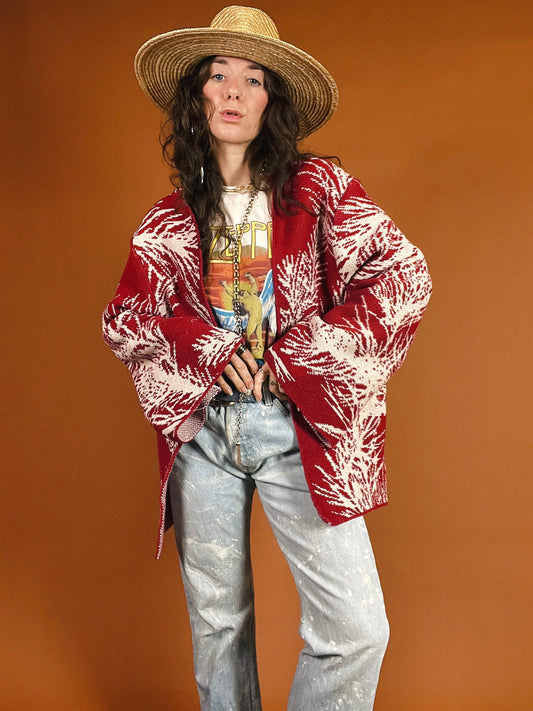 A woman in jeans and a hat is posing for a photo.