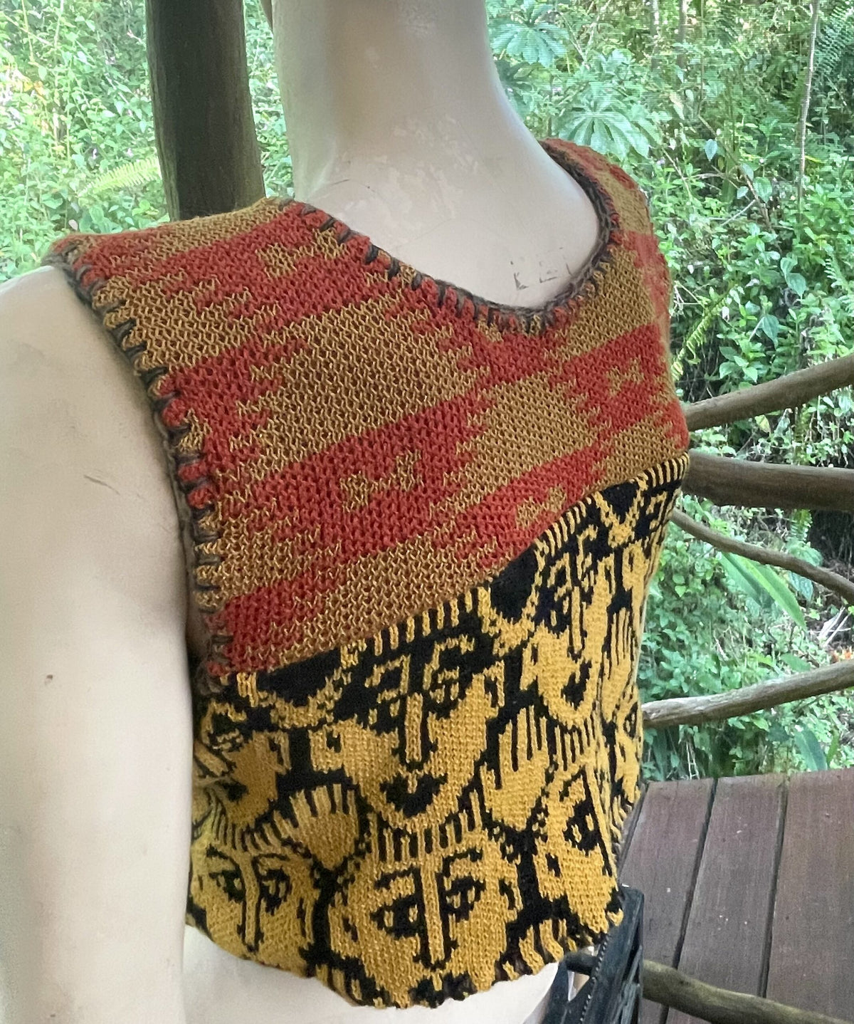 a mannequin wearing a colorful knitted top.