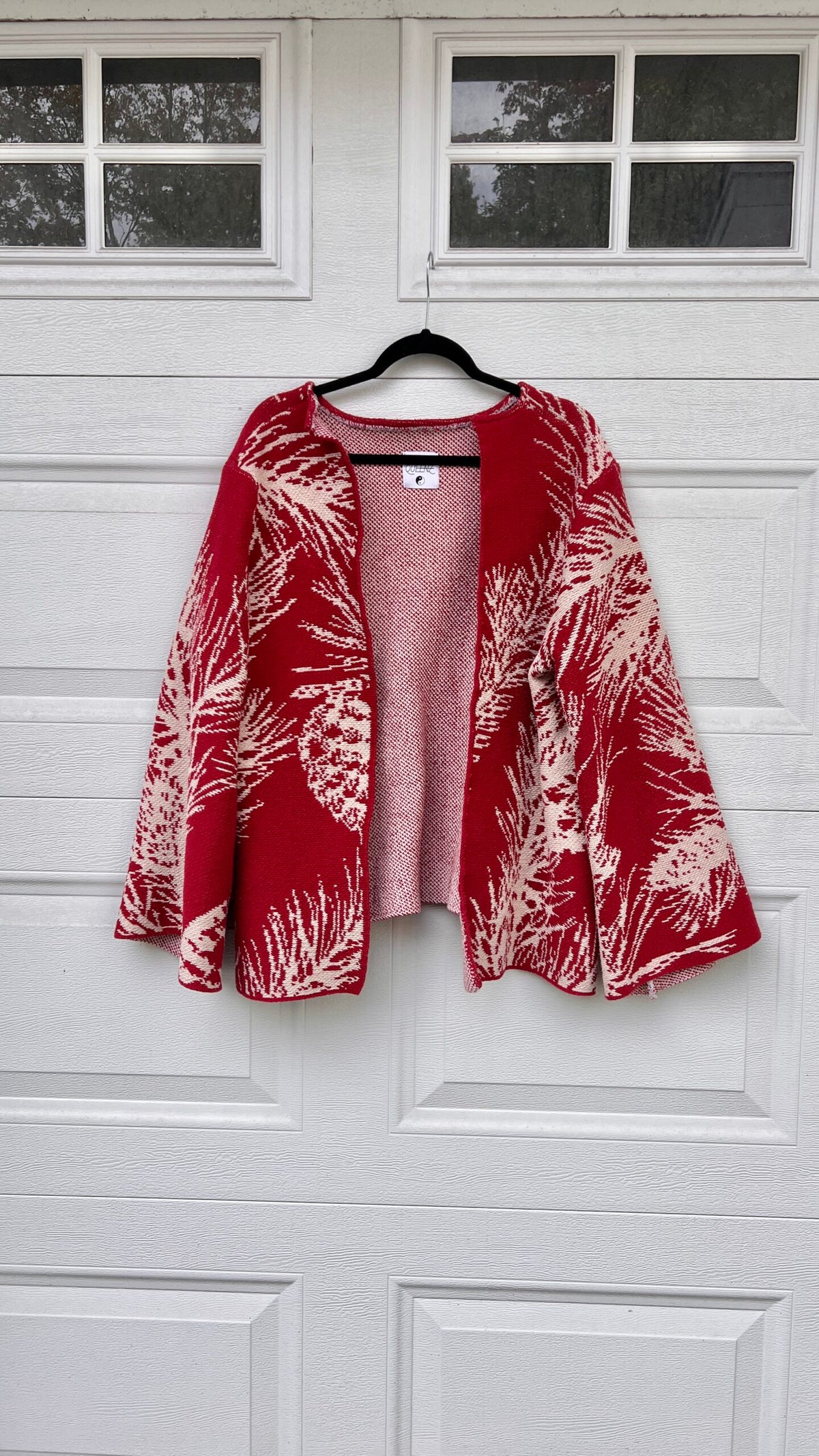 A red and white jacket hanging on a garage door.