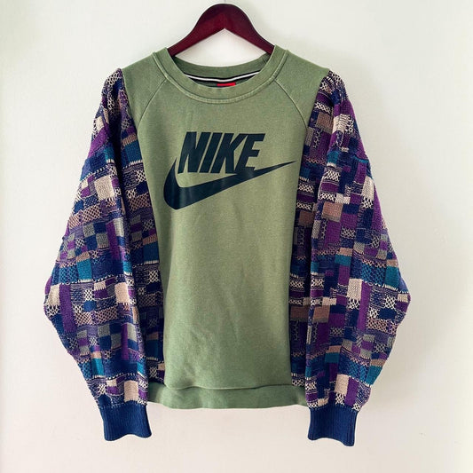 A nike sweatshirt is hanging on a wall.