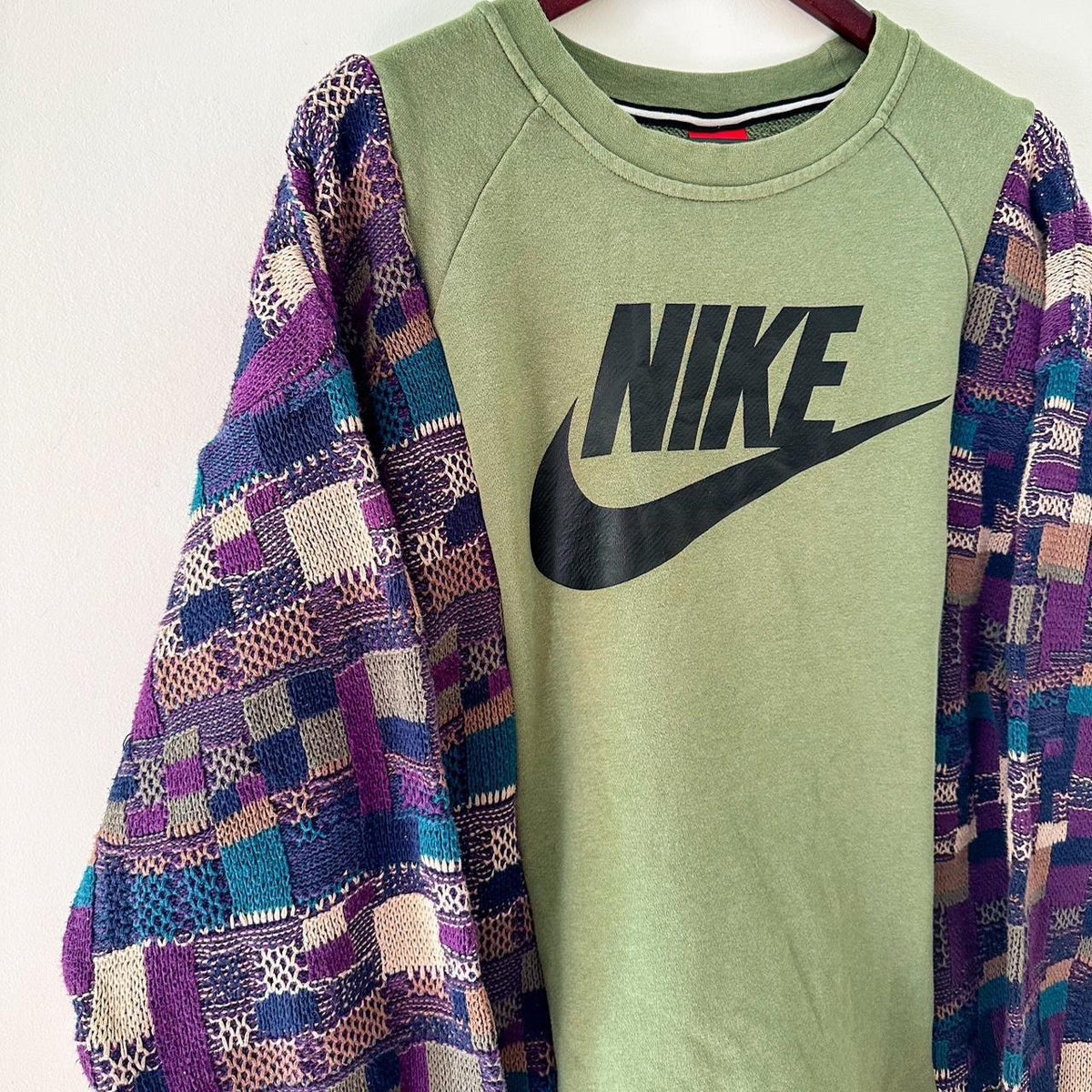 A green sweatshirt with a nike logo on it.