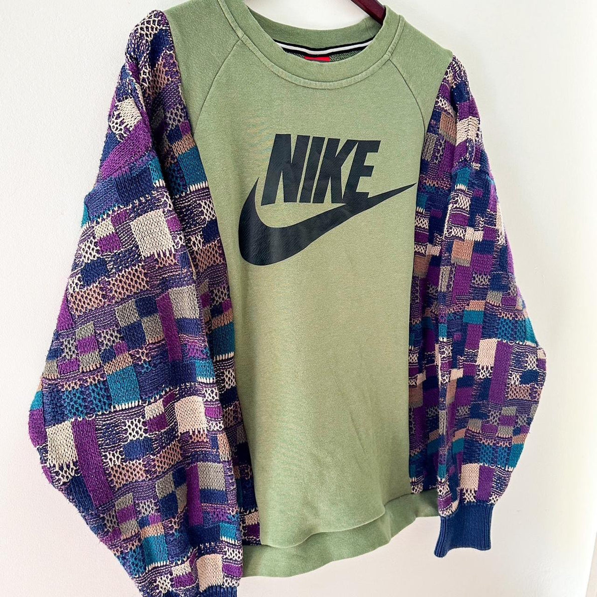 A nike sweatshirt hanging on a hanger.