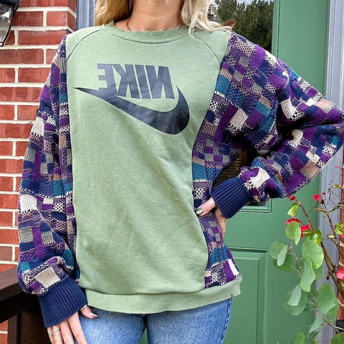 A woman wearing a green and purple nike sweatshirt.