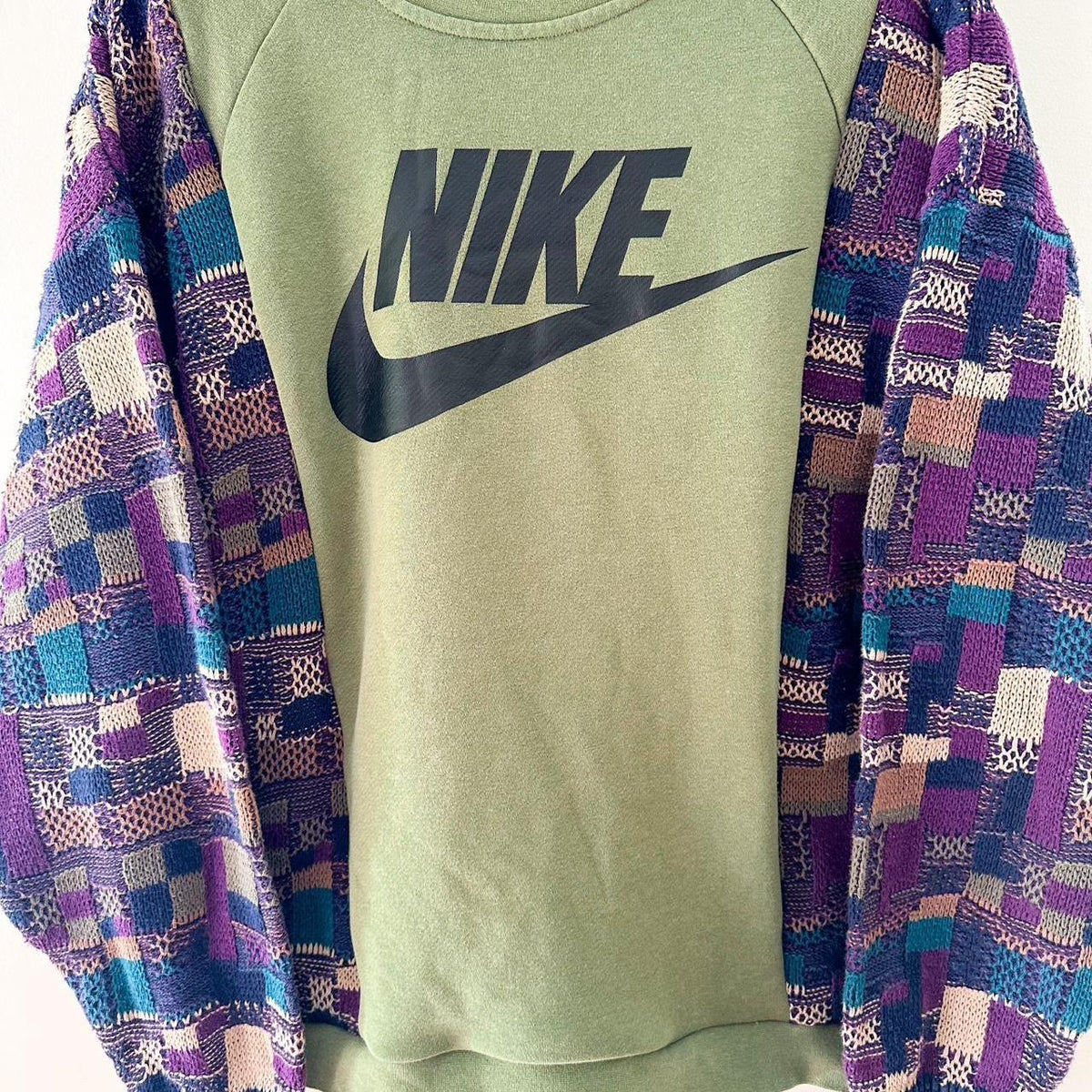 A nike sweatshirt with a patchwork pattern on it.