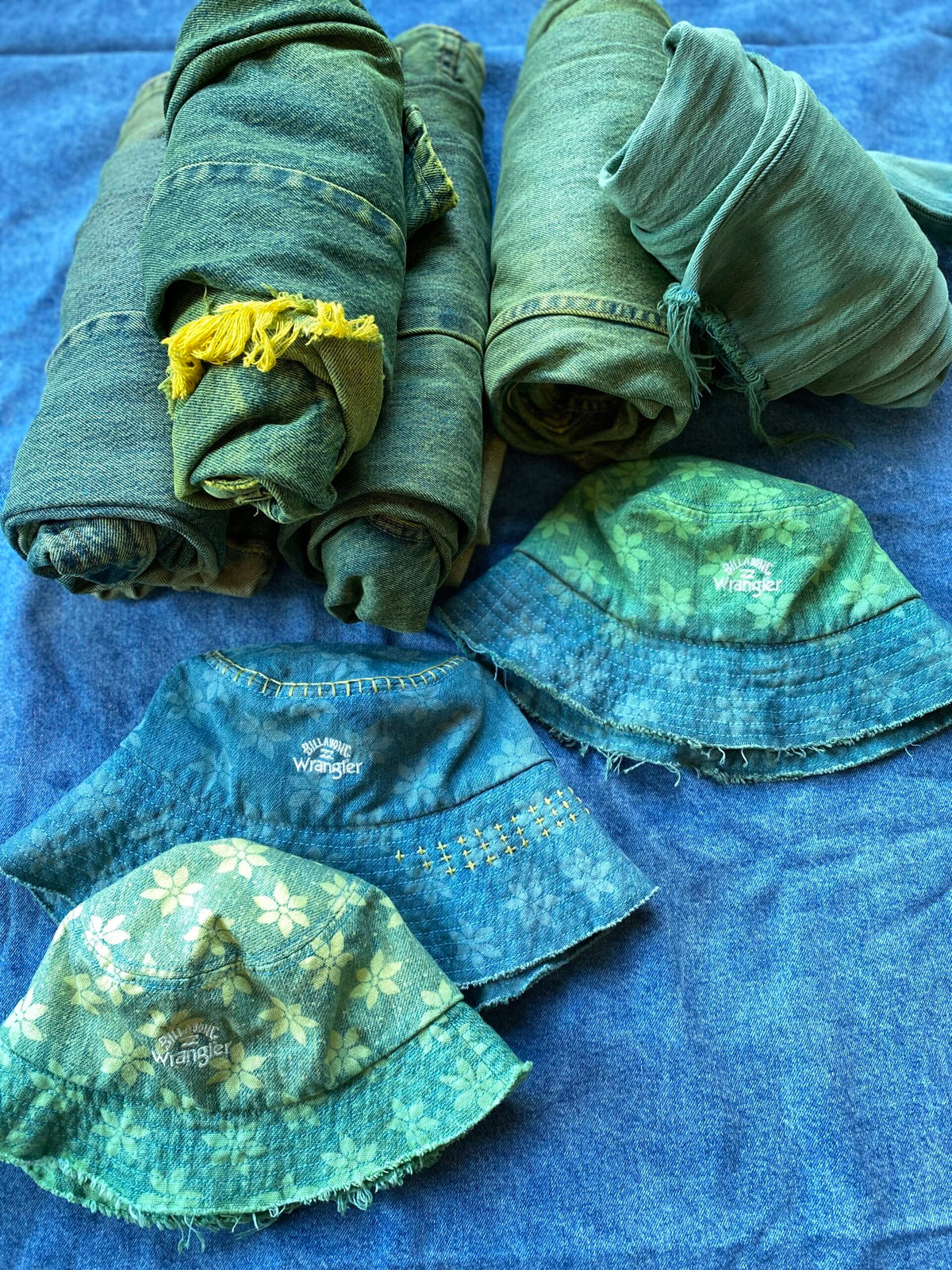 A stack of green hats on a blue cloth.