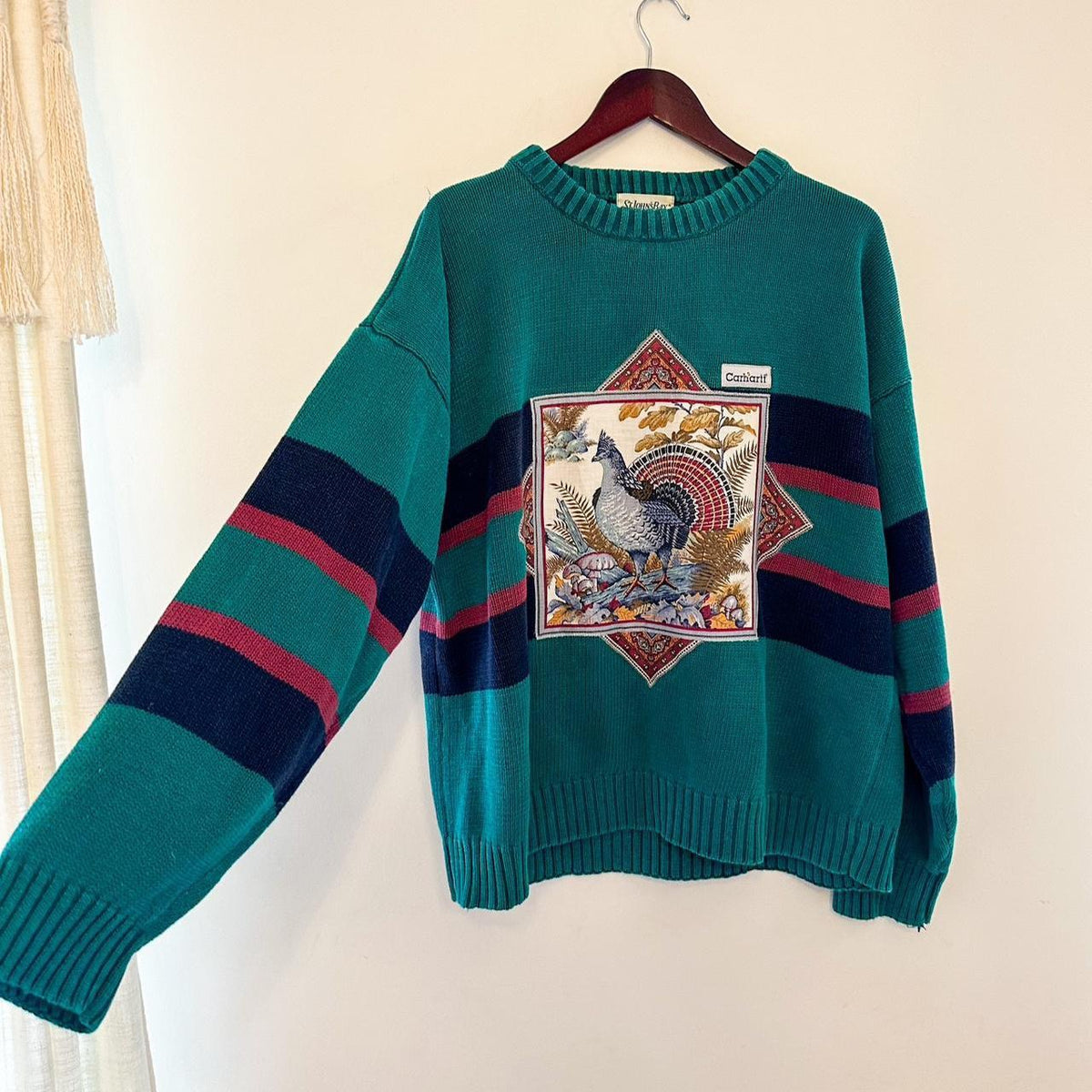 A green sweater with a turkey on it.