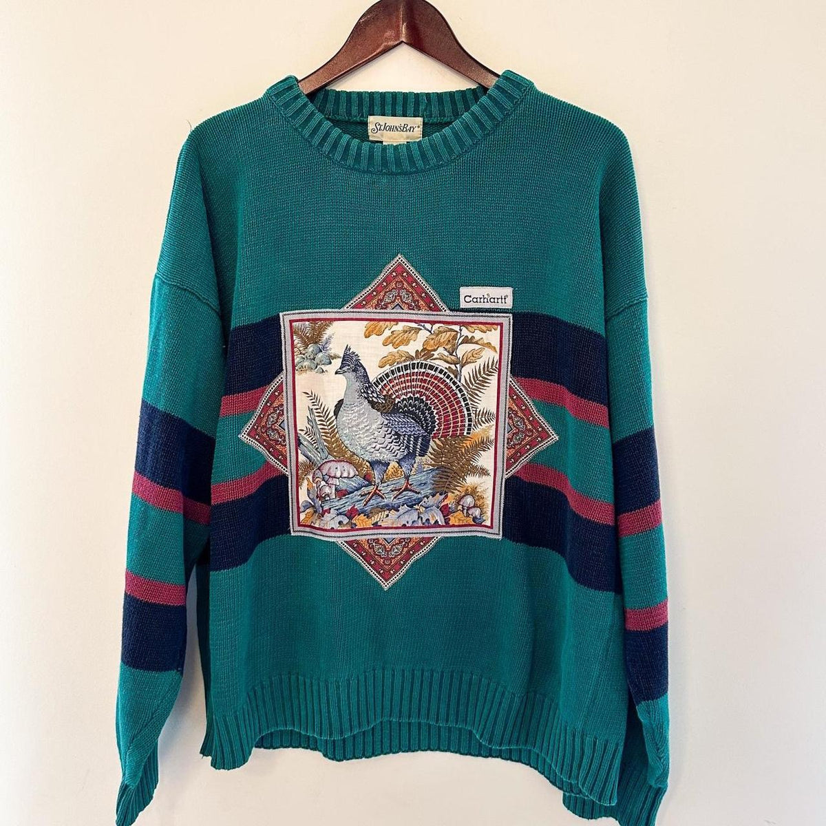 A green sweater with an image of a turkey on it.