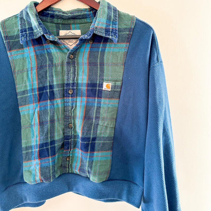A blue and green plaid shirt hanging on a hanger.