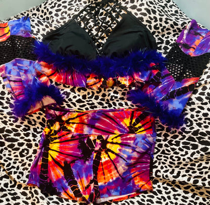 A colorful tie dye bikini set on a leopard print bed.