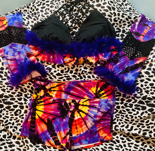 A colorful tie dye bikini set on a leopard print bed.